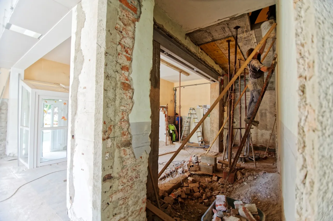 Interior renovation with exposed brickwork, ladders and construction debris